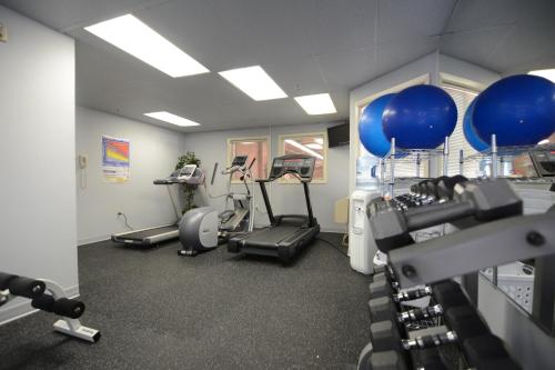 a gym with treadmills and machines in a room at Century Hotel in Tualatin