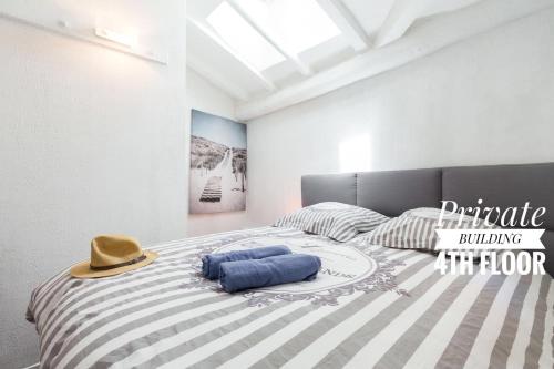 une chambre avec un lit avec un chapeau dessus dans l'établissement PRIVATE BUILDING, 4 APTS, UNIQUE AT NICE- OLD TOWN, à Nice