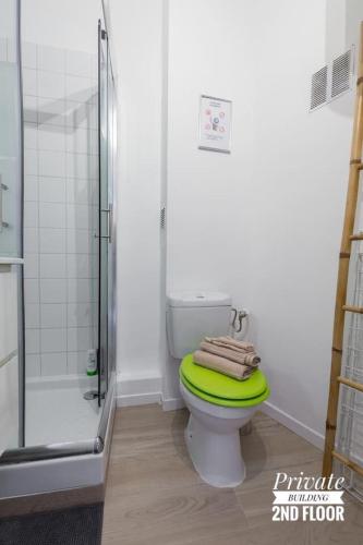 La salle de bains est pourvue d'une douche et de toilettes avec un siège vert. dans l'établissement PRIVATE BUILDING, 4 APTS, UNIQUE AT NICE- OLD TOWN, à Nice