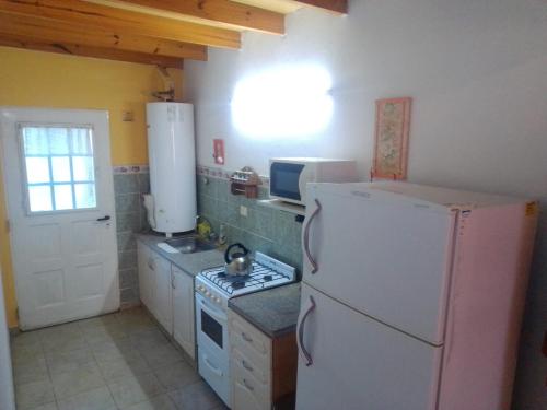 a kitchen with a white refrigerator and a stove at Altas Mareas 2 in Las Grutas