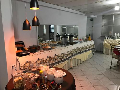 a buffet line in a kitchen with food on it at Hotel Alfa de Bauru Ltda in Bauru