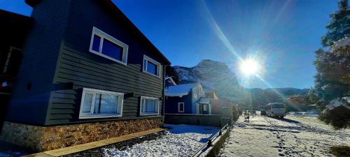 a building with the sun in the sky behind it at Aparts Merkaba in El Chalten
