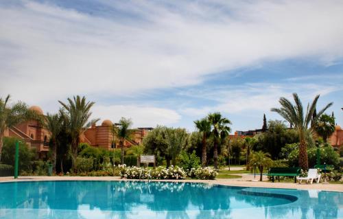una piscina en un complejo con palmeras en Duplex Atlas Golf Resort Pοοl νieω Seriniτყ & Cαlm, en Marrakech