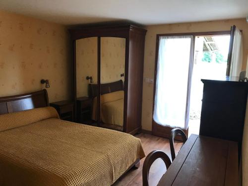 een slaapkamer met een bed en een raam bij La maison de Laujol in Moissac