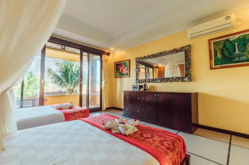 a bedroom with two beds and a mirror at Pondok Kutuh Guest House in Ubud