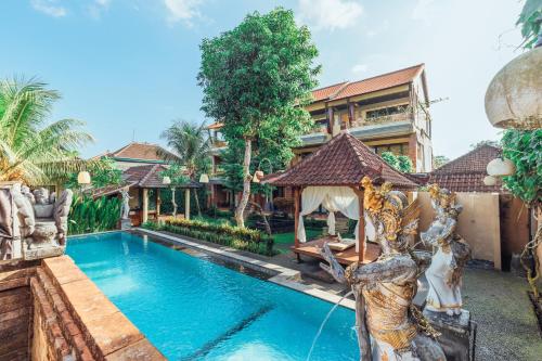 a swimming pool in front of a villa at Pondok Kutuh Guest House in Ubud