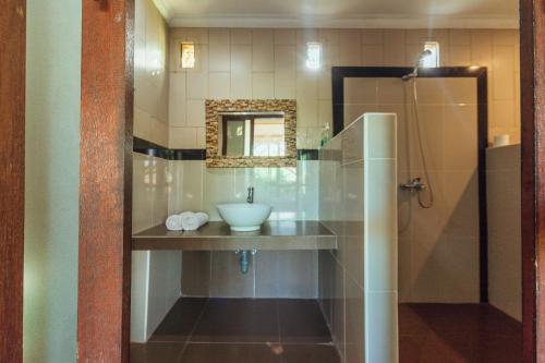 a bathroom with a sink and a mirror at Pondok Kutuh Guest House in Ubud