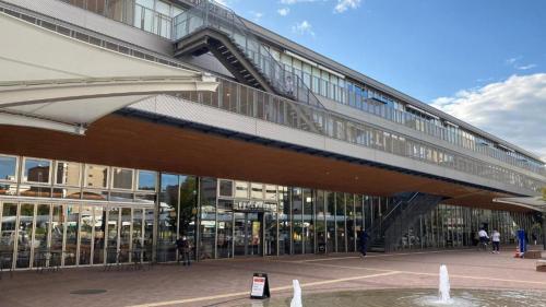 a bridge over a building with a fountain in front of it at Toyoko Inn Tokuyama-eki Shinkansen-guchi in Shunan