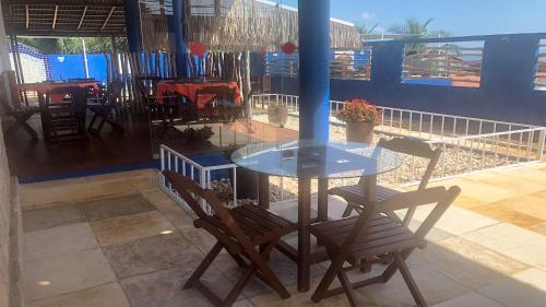 un tavolo di vetro con due sedie e un tavolo e un tavolo e sedie di Pousada do Sol a Lagoinha