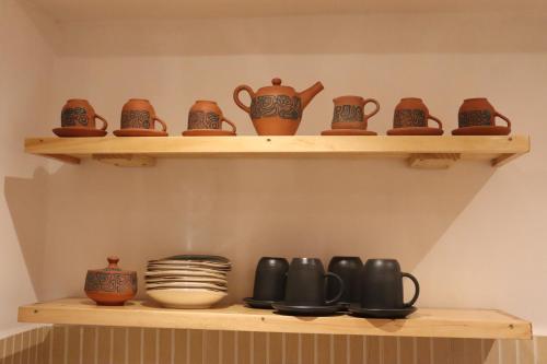 a shelf with cups and other pottery on it at Casa Gabriel in Cusco