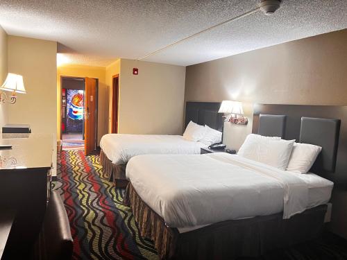 a hotel room with two beds with white sheets at Apple Tree Inn in Independence