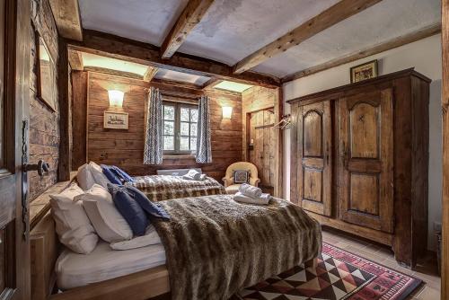 Chalet Heron في لي أوش: غرفة نوم بسريرين في غرفة بجدران خشبية