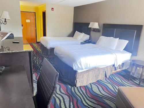 a hotel room with two beds and a table and chairs at Apple Tree Inn in Independence