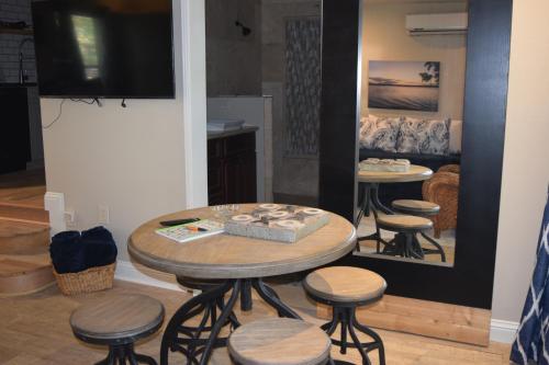 a table and stools in a room with a tv at Lake front Studio in Little Elm
