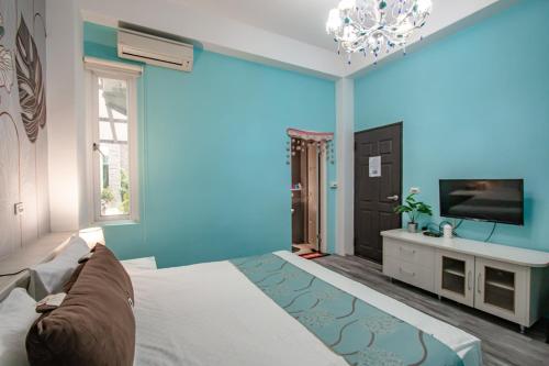 a blue room with a bed and a tv at Hualien Feel at Home BnB in Hualien City