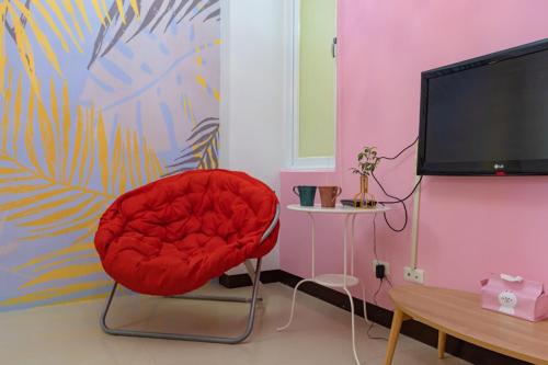 a red chair sitting in a room with a tv at Hualien Feel at Home BnB in Hualien City