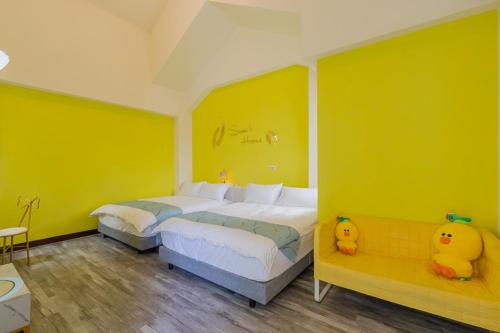 a bedroom with two beds and yellow walls at Hualien Feel at Home BnB in Hualien City