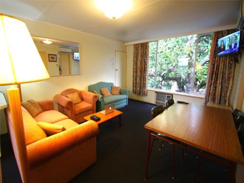 ein Wohnzimmer mit einem Sofa, Stühlen und einem Tisch in der Unterkunft Motel Maroondah in Box Hill