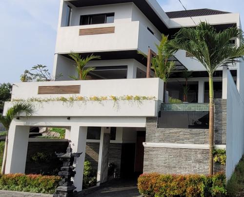 a white house with palm trees in front of it at Villa Mimpi Bali in Jimbaran
