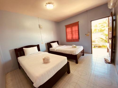 une chambre d'hôtel avec deux lits et une fenêtre dans l'établissement Phupha Bungalow Haad Rin, à Haad Rin