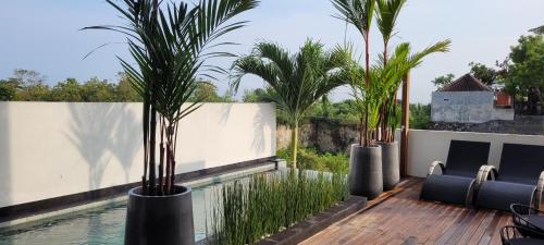 a swimming pool with palm trees on a house at Villa Mimpi Bali in Jimbaran
