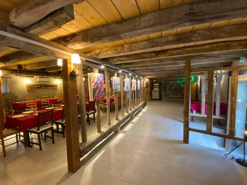 une salle à manger avec des tables et des chaises rouges dans l'établissement Grand Gîte au Berry avec Terrasse, Pétanque et Confort Tout Inclus - Lac d'Eguzon Proche - FR-1-591-355, à Orsennes