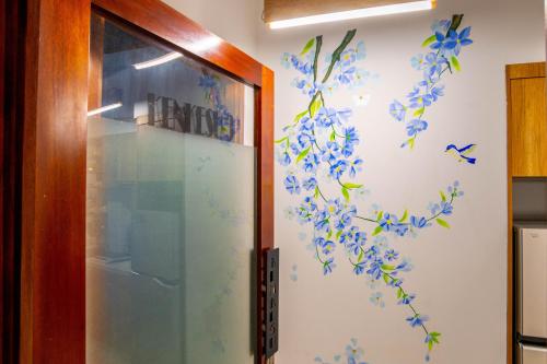a door with blue flowers on a wall at KenKeSu House-Nice third Aprt-2BRs- Free airport pick up from 2 nights in Da Nang