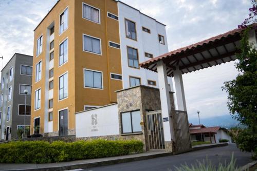 a yellow and white building next to a street at Apartamento a 2.5 km del parque del café in Montenegro