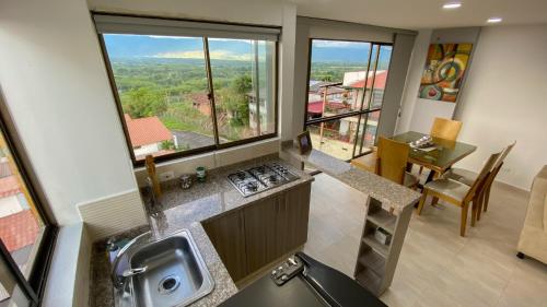 cocina con fregadero y encimera con ventana en Apartamento a 2.5 km del parque del café, en Montenegro