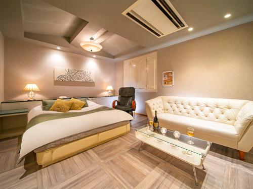堺市的住宿－QT仙北酒店（僅限成人），一间卧室配有一张床和一张沙发