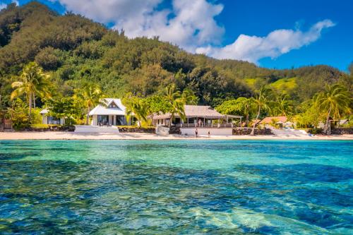 an island in the ocean with houses and palm trees at Moorea Island Beach Hotel in Moorea