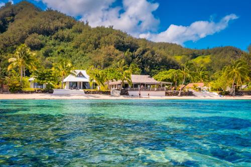 una isla en el océano con casas y palmeras en Moorea Island Beach Hotel en Moorea