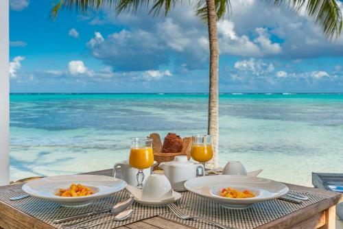 a table with breakfast on the beach with the ocean at Moorea Island Beach Hotel in Moorea