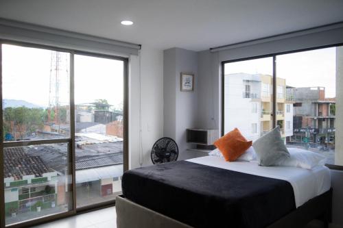a bedroom with a bed and a large window at Apartamento con hermosa vista a 5 minutos del parque del café in Montenegro