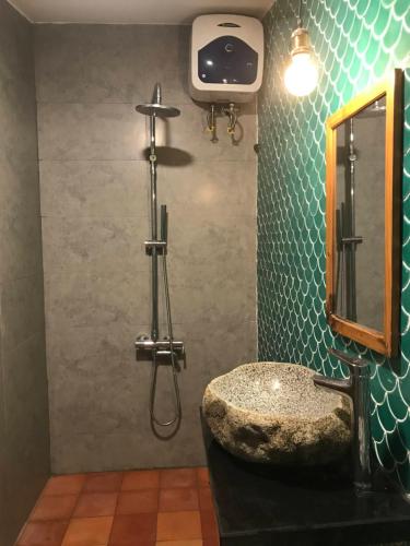 a bathroom with a stone sink and a shower at La Sen-Thu An-Có cửa sổ nhìn ra ban công in Thôn An Hòa