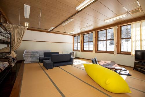 a living room with a yellow surfboard on the floor at Mori no Bunkou Fuzawa - Vacation STAY 93238v in Kobayashi