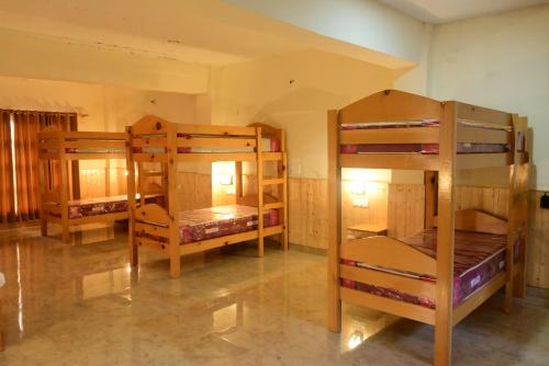 a room with three bunk beds in a room at Munsyari The Roof Top in Munsyari