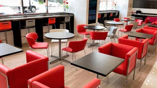 a restaurant with red chairs and tables in a room at Toyoko Inn Hiroshima-eki Stadium Mae in Hiroshima