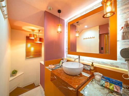 a bathroom with a sink and a mirror at Hotel GT Kansai International Airport (Adult Only) in Sennan