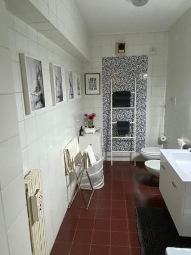 Baño blanco con 2 aseos y lavamanos en Mandi Mandi al centro, en Udine
