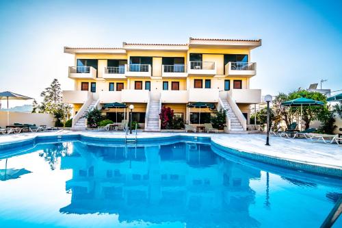 a hotel with a pool in front of a building at Orestis Hotel Sea View Apartments in Stalos