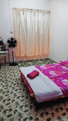 HOMESTAY UMI KODIANG في Kodiang: غرفة نوم مع سرير وملاءات وردية ونافذة