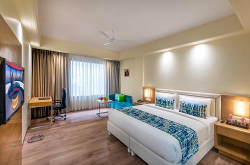 a hotel room with a large bed and a desk at Lords Inn Jaipur in Jaipur