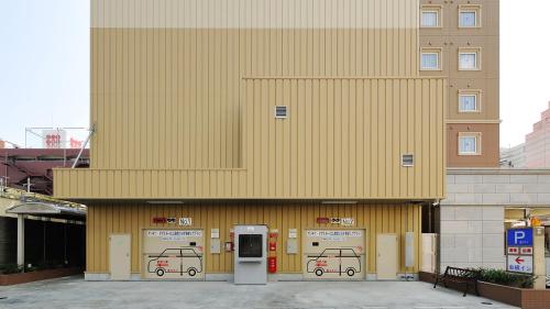 a building with three parking machines in front of it at Toyoko Inn Okayama eki Higashi guchi in Okayama