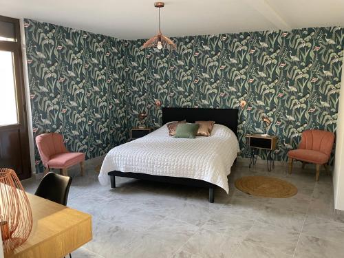 1 dormitorio con 1 cama con papel pintado verde y blanco en Le Gîte du père Chayoux, en Champillon