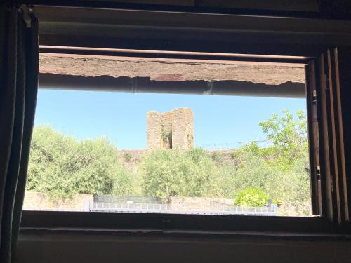 an open window with a view of a brick tower at Monteriggioni Castello in Monteriggioni