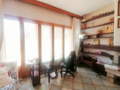 Zimmer mit einem Schreibtisch, einem Stuhl und Fenstern in der Unterkunft Villa Floris giardino AIRCON WIFI Parcheggio in Ostuni