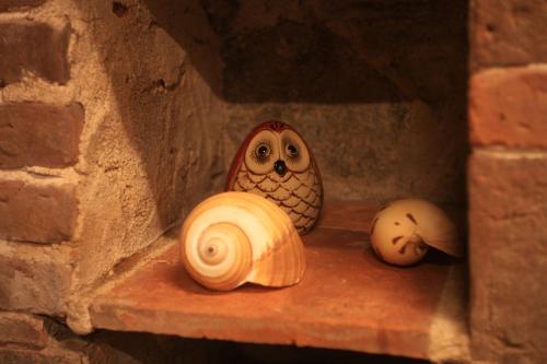 an owl figurine sitting on a shelf in a brick wall at Pearl B&B in Jinsha