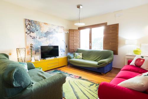 a living room with two couches and a tv at Finca Olivar de Castilla - Sun&Colors in Segovia