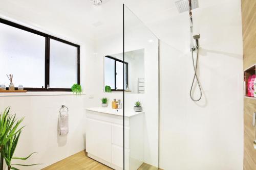 a white bathroom with a glass shower stall at Wildwood I Pet Friendly I 5 Mins to Beach in Callala Beach